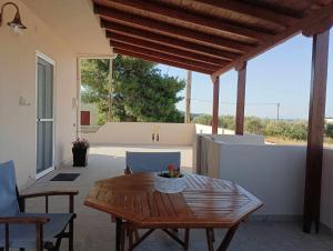 a wooden table and chairs on a patio at La Casa Di Kokkines in Plytra