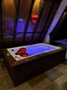 a jacuzzi tub with red peppers in it at Chalé Guiados Pelo Alto in São Pedro de Alcântara +32 photos