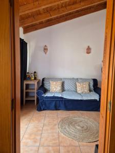 a blue couch in a living room with a table at Casa da Ribeira in Aldeia Nova do Concelho +19 photos