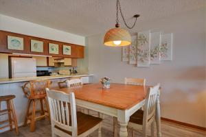 une cuisine et une salle à manger avec une table et des chaises en bois dans l'établissement Queens Grant B-106, à Topsail Beach