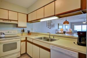 une cuisine avec un évier et une cuisinière dans l'établissement Queens Grant B-106, à Topsail Beach 17 autres photos