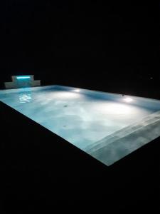 Una gran piscina de agua azul con luces. en La Maison Genevier - Chambre Marguerite, en Montreuil-en-Touraine