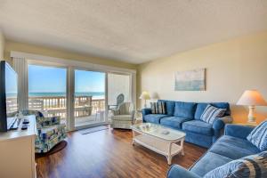een woonkamer met blauwe meubels en uitzicht op de oceaan bij Queen's Grant C-109 in Topsail Beach