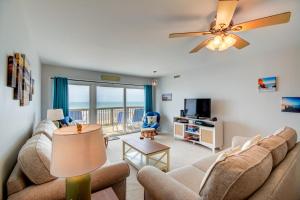 トップセール・ビーチにあるQueen's Grant E-216のソファと天井ファンのあるリビングルーム