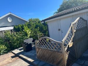 a wooden bench sitting next to a building at Algutsrumsro Stuga på Öland in Färjestaden