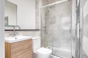 Un baño con inodoro, lavabo y ducha. en Sloane House, en Birmingham