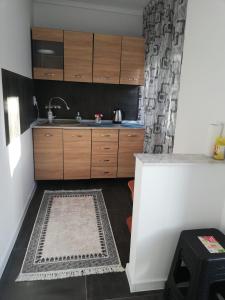 a kitchen with a sink and wooden cabinets at Căsuța de vacanță in Năvodari +7 photos