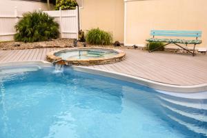 ein Pool mit einer Bank neben einem Gebäude in der Unterkunft Shore Blessed in North Topsail Beach