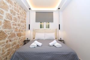 a bedroom with a bed with two white pillows at Lalos Apartment in Egina