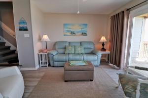 een woonkamer met een blauwe bank en een stoel bij Turtle Cove 908D in Surf City +38 foto's