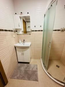 a small bathroom with a sink and a shower at Shtastliveca Guest Apartment in Velingrad +18 photos