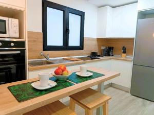 a kitchen with a table with a bowl of fruit on it at Deluxe Arguineguin Beach in Arguineguín