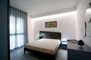 a bedroom with a bed and a table and a window at villa grecale in Castellammare del Golfo