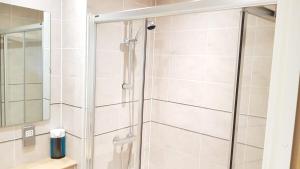a shower with a glass door in a bathroom at KCS Birmingham City Apartment with Balcony/Parking in Birmingham