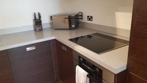 a kitchen with a counter top with a stove top at KCS Birmingham City Apartment with Balcony/Parking in Birmingham