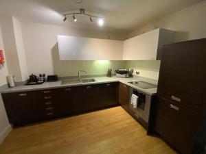 a kitchen with a sink and a stove at KCS Birmingham City Apartment with Balcony/Parking in Birmingham