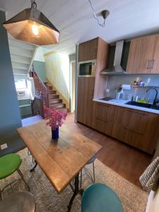 a kitchen with a wooden table with flowers on it at Station Volubile - Gîte d'étape in Guissény