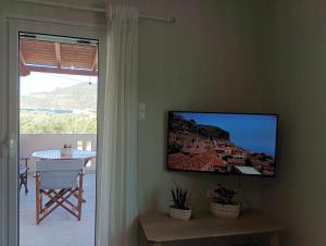 a living room with a flat screen tv on the wall at La Casa Di Kokkines in Plytra