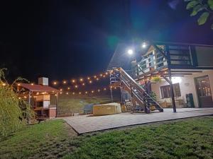 a house with a staircase and lights in the night at Cabana Petersdorf in Petreşti