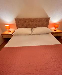 a bedroom with a large bed with two lamps on tables at Villa Radulj in Kozarica