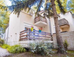 a house with a tree in front of it at Nyaraló Apartman in Siófok