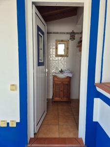 a bathroom with a sink and a blue and white door at Casa da Ribeira in Aldeia Nova do Concelho