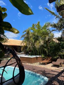 a swimming pool in a resort with palm trees at Pousada da Praia in Garopaba +12 photos