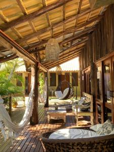 an outdoor patio with hammocks and a table and chairs at Pousada da Praia in Garopaba