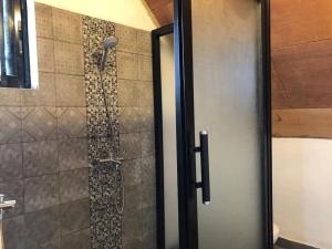 una doccia in un bagno con una porta in vetro di Villa tropical a Kribi