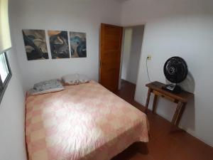a bedroom with a bed and a fan at Recanto São Sebastião in São Sebastião