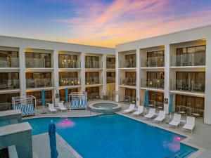 a large swimming pool in a building with chairs and a pool at Hilton College Station & Conference Center in College Station