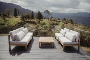 a group of couches and a coffee table on a deck at La Vita é Bella Glamping in Machetá