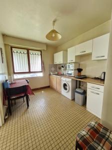 eine Küche mit einem Tisch und einer Waschmaschine in der Unterkunft Vaste studio 10 min ORLY 20 min Paris by RER B in Massy