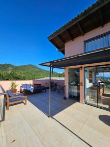 a house with a patio with a view of the ocean at Casa da Flôr GuestHouse, Praia Grande, Beto Carrero in Penha
