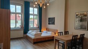 a room with a bed and a table with a dining room at Drzewna Apartamenty - Żeromskiego in Zielona Góra