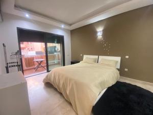 a bedroom with a large bed and a balcony at new and modern apartment in Marrakesh