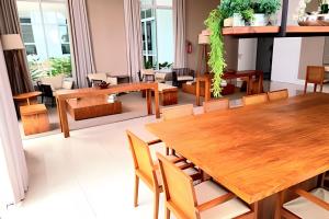 una sala da pranzo con tavoli e sedie in legno di Bayview Luxury Umarizal a Belém