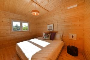 a bedroom with a bed in a wooden cabin at Quinta da Aldeia Nova in Arganil
