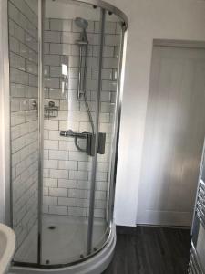 a shower with a glass door in a bathroom at Cheerful 3 Bedroom Townhouse in Bangor +15 photos