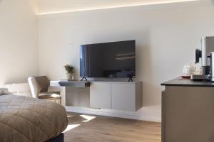 a bedroom with a large television on a wall at Lake Music in Brissago