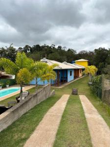 a house with a swimming pool and a yard at Vila Verde Chalés-Suíte Aconchego in Sêrro