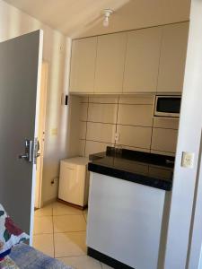 カルダス・ノバスにあるFlat THERMAS PLACEの小さなキッチン(白いキャビネット、電子レンジ付)