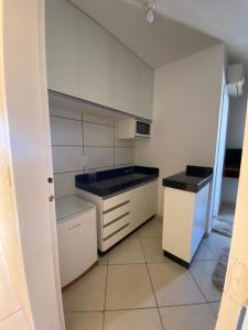 カルダス・ノバスにあるFlat THERMAS PLACEの白いキャビネットと黒いカウンタートップを備えたキッチン