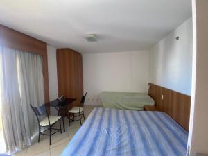 カルダス・ノバスにあるFlat THERMAS PLACEのベッドとテーブルと椅子のある寝室