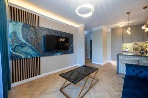 a living room with a large painting on the wall at Golden Park Aparthotel in Szczecin