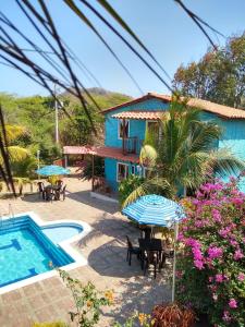 a resort with a pool and tables and umbrellas at Hostal las Cabañas Santa Veronica in Santa Veronica