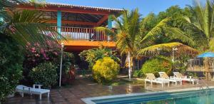a resort with a pool with chairs and a balcony at Hostal las Cabañas Santa Veronica in Santa Veronica