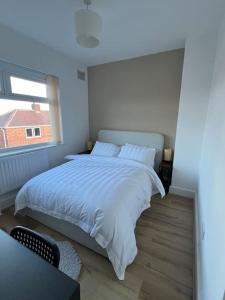 une chambre avec un grand lit blanc avec une fenêtre dans l'établissement Whole House Modern Two Bedroom in Newcastle - Free Parking, à Newcastle upon Tyne 12 autres photos