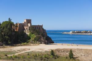 a castle on a hill next to a beach at Vila Castelo Parque in Ferragudo