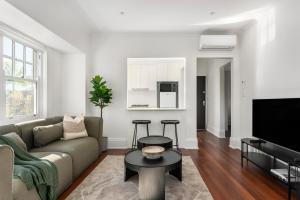 una sala de estar con un sofá y una mesa en Bondi Junction Apartments by Urban Rest, en Sídney